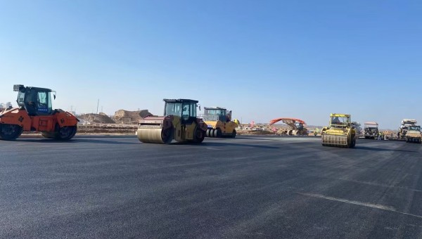 近日，在西部市政建設(shè)集團(tuán)蘭州新區(qū)城市礦產(chǎn)與表面處理產(chǎn)業(yè)園區(qū)（二期）周邊基礎(chǔ)設(shè)施項(xiàng)目—園區(qū)西路南延段（緯五十路至緯二十八路）項(xiàng)目現(xiàn)場(chǎng)，隨著一輛輛運(yùn)料車(chē)平穩(wěn)駛?cè)?，攤鋪機(jī)將滾燙的瀝青混合料均勻鋪開(kāi)，標(biāo)志著項(xiàng)